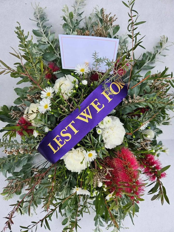 Lest We Forget floral wreath with white daisies, red bottlebrush, and greenery for remembrance
