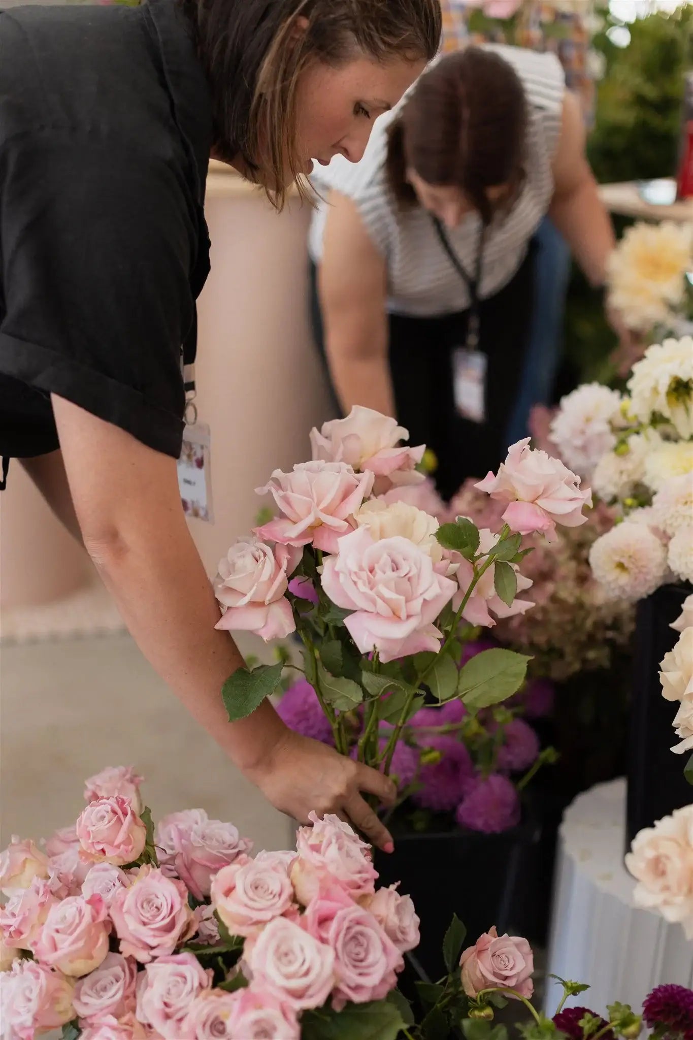 Pink roses and flowers arranged at a garden market stall, perfect for meadow gardens and cut flower patches.