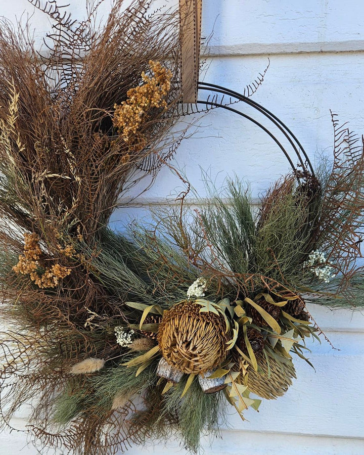 Decorative wreath with natural elements on a white wooden background