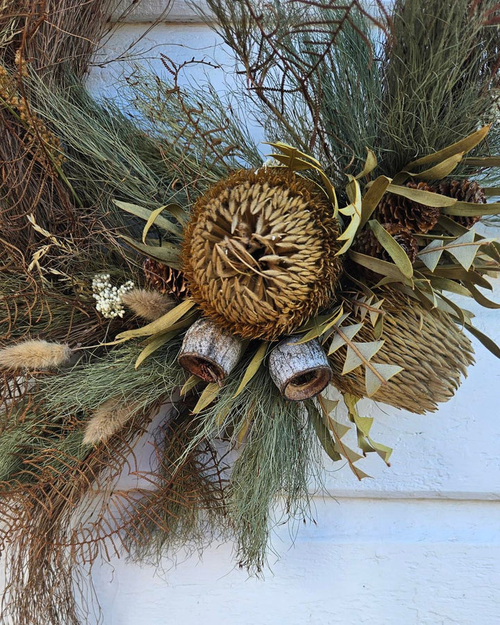 Decorative wreath with natural elements on a white wooden background