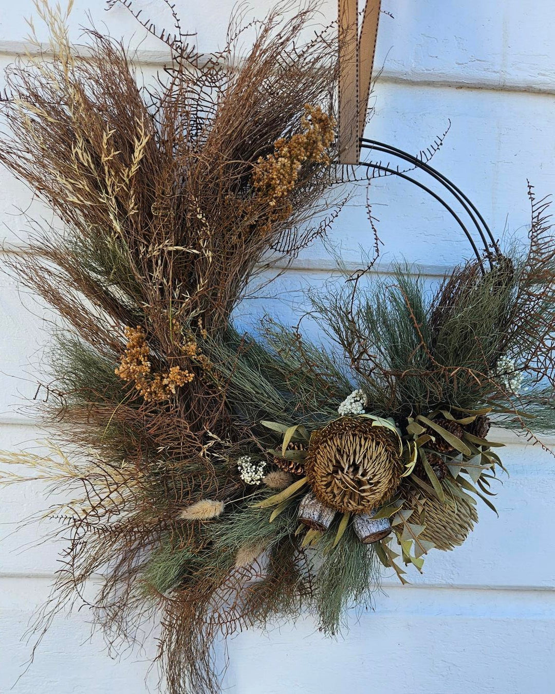 Decorative wreath with natural elements on a white door