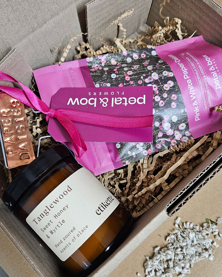 Copper lable, candle and seed packet packaged up onto a ready to gift, christmas giftbox. 