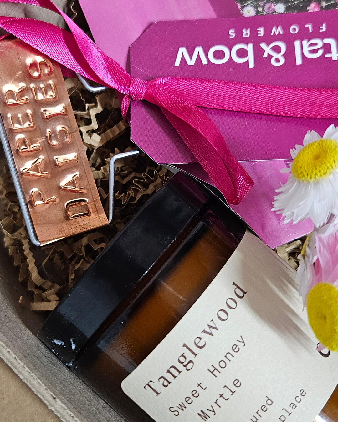 Paper Daisy Seeds with a candle and copper flower tag. 