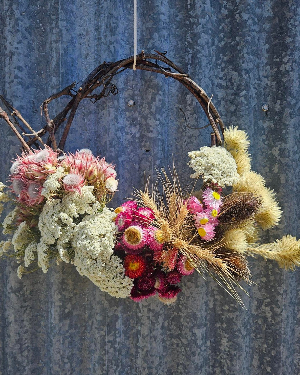Floral wreath with dried flowers and pink flowers. 